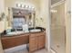 Double vanity sinks, a large mirror, and a walk-in shower at 8101 Resort Village Dr, Orlando, FL 32821