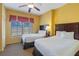 Two twin beds, nightstands, and a ceiling fan at 8101 Resort Village Dr, Orlando, FL 32821
