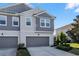 Two-story townhome with gray siding, two-car garage, and landscaping at 9053 Shepton St, Orlando, FL 32825