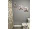 Bathroom with gray walls, white toilet, and decorative wall art at 943 Derbyshire Dr, Kissimmee, FL 34758