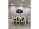 Dining room with white table and chairs, and a unique wall art piece at 943 Derbyshire Dr, Kissimmee, FL 34758
