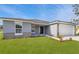 One-story home with gray exterior, stone accents, and a white garage door at 943 Derbyshire Dr, Kissimmee, FL 34758