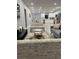 Open living room and kitchen with gray sofa and white kitchen cabinets at 943 Derbyshire Dr, Kissimmee, FL 34758