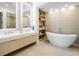 Bright bathroom featuring dual sinks, a freestanding soaking tub, and a separate shower with a neutral color palette at 9697 Bryanston Dr, Orlando, FL 32827