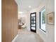 Bright entryway with wood accent wall and view to kitchen at 9697 Bryanston Dr, Orlando, FL 32827