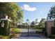 Elegant gated entrance leading to a private estate, surrounded by mature trees at 9697 Bryanston Dr, Orlando, FL 32827