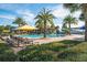 Resort-style pool with palm trees, umbrellas, and lounge chairs at 125 Silver Maple Rd Rd, Groveland, FL 34736