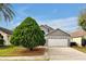 Two-story house with gray exterior and white garage door, plus a large tree at 12821 Gettysburg Cir, Orlando, FL 32837