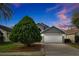 Gray house with white garage door, landscaping, and a driveway at 12821 Gettysburg Cir, Orlando, FL 32837