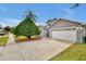 Gray house with white garage door and driveway, next to a palm tree at 12821 Gettysburg Cir, Orlando, FL 32837