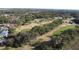 Aerial view of a golf course with trees and a pond nearby at 1501 Edgewater Dr, Mount Dora, FL 32757