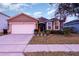 House exterior featuring a two-car garage and well-manicured lawn at 1569 Tamarind Rd, Davenport, FL 33896