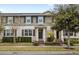 Two-story townhome with green exterior, landscaping, and walkway at 16133 Pebble Bluff Loop, Winter Garden, FL 34787