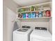 Laundry room with washer, dryer, and ample storage shelves at 16133 Pebble Bluff Loop, Winter Garden, FL 34787