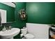 Modern powder room with green walls, white subway tile, and a pedestal sink at 16926 Reseda Aly, Winter Garden, FL 34787