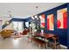 Mid-century modern dining area with a wooden table and blue accent wall at 16926 Reseda Aly, Winter Garden, FL 34787