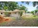 House under renovation, showcasing the side exterior and a trampoline in the backyard at 1705 Geigel Ave, Orlando, FL 32806