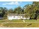 White single-story house with attached garage, driveway, and landscaped lawn at 208 S Main Ave, Minneola, FL 34715