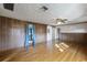 Living room with hardwood floors, wood paneling, and ceiling fan at 208 S Main Ave, Minneola, FL 34715