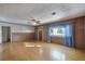 Living room with hardwood floors, wood paneling, and ceiling fan at 208 S Main Ave, Minneola, FL 34715