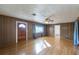 Living room with hardwood floors, wood paneling, and ceiling fan at 208 S Main Ave, Minneola, FL 34715