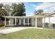 Updated bungalow exterior featuring a covered porch and well-manicured lawn at 2420 Musselwhite Ave, Orlando, FL 32804