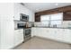 Modern white kitchen with stainless steel appliances and wood accent wall at 2420 Musselwhite Ave, Orlando, FL 32804