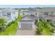 Two-story house, gray siding, gray garage, and a brick paver driveway; surrounded by other homes at 2438 Pearl Cider Street, Orlando, FL 32824