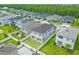 Aerial view showcasing a neighborhood of houses with gray siding, solar panels, and lush landscaping at 2438 Pearl Cider Street, Orlando, FL 32824