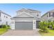 Two-story house with gray siding, a gray three-car garage, and a brick paver driveway at 2438 Pearl Cider Street, Orlando, FL 32824