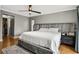 Main bedroom with plush bed, grey headboard and wood flooring at 2564 Sheffield Ave, Orlando, FL 32806