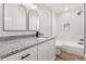 Modern bathroom with granite countertop, white cabinets, and black accents at 25753 Vero St, Sorrento, FL 32776