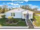 Cute bungalow with a light blue exterior, stone steps, and nicely landscaped yard at 305 S Halifax Dr, Ormond Beach, FL 32176