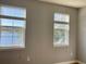 Bedroom with lake view, two windows with blinds, and neutral walls at 3250 Corona Village Way # 302, Orlando, FL 32835