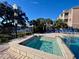Community pool and hot tub with lounge chairs at 3250 Corona Village Way # 302, Orlando, FL 32835
