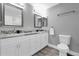 Modern bathroom with a dual vanity, granite countertops, modern mirrors and luxury vinyl plank flooring at 3334 N Westmoreland Dr, Orlando, FL 32804