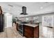 Gourmet kitchen island with stainless steel cooktop and exhaust hood, granite countertops, and open to the living spaces at 3334 N Westmoreland Dr, Orlando, FL 32804