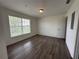 Bright bedroom with large window and wood-look flooring at 3724 Castle Pines Ln # 4237, Orlando, FL 32839