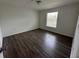 Large bedroom with dark laminate floors and a window at 3724 Castle Pines Ln # 4237, Orlando, FL 32839