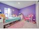 Bright bedroom with purple walls, a comfy bed, and plenty of space for toys at 3842 Whitetail Ct, St Cloud, FL 34772