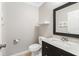 Stylish bathroom, featuring a dark vanity with marble top and a framed mirror at 4302 Clubside Dr # 4302, Longwood, FL 32779