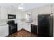 Galley kitchen with black appliances and wood floors at 4302 Clubside Dr # 4302, Longwood, FL 32779