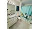 Bathroom with granite vanity, teal shower curtain, and wood-look floors at 4563 Yellowgold E Rd # 108, Kissimmee, FL 34746