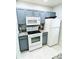 Granite countertops, gray cabinets, and white appliances in this galley kitchen at 4563 Yellowgold E Rd # 108, Kissimmee, FL 34746