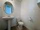 Simple bathroom with pedestal sink, toilet and round mirror at 459 Windmill Palm Cir, Altamonte Springs, FL 32701