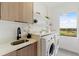 Laundry room with washer, dryer, and a modern sink at 6230 Chorus Dr, Mascotte, FL 34753