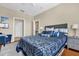 Bedroom featuring a large bed with plush pillows, a gray nightstand, and a doorway leading to another room at 6413 Astor Village Ave # 313, Orlando, FL 32835