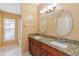 Bathroom with dual sinks, granite countertops, framed mirrors, and white cabinets at 7812 Wicklow Cir, Orlando, FL 32817