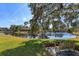 Peaceful lakefront setting with a wooden bench under a shade tree at 812 Edgeforest Ter, Sanford, FL 32771