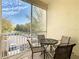 Private screened balcony with table and chairs, overlooking parking at 8908 Legacy Ct # 201, Kissimmee, FL 34747